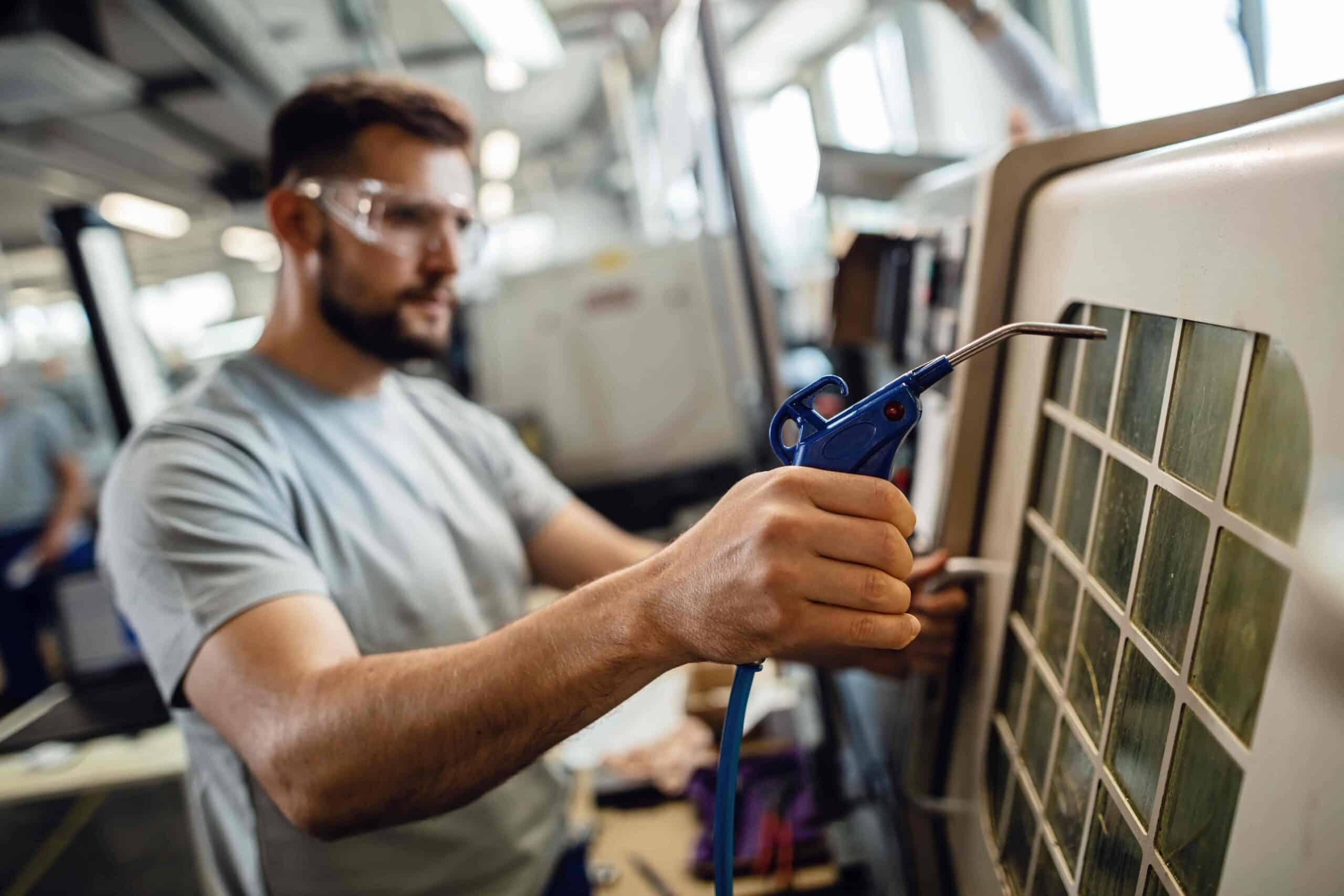 Technician cleaning equipment with air compressor