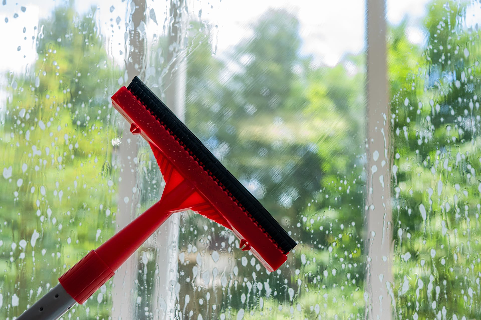 Squeegee cleaning soapy window