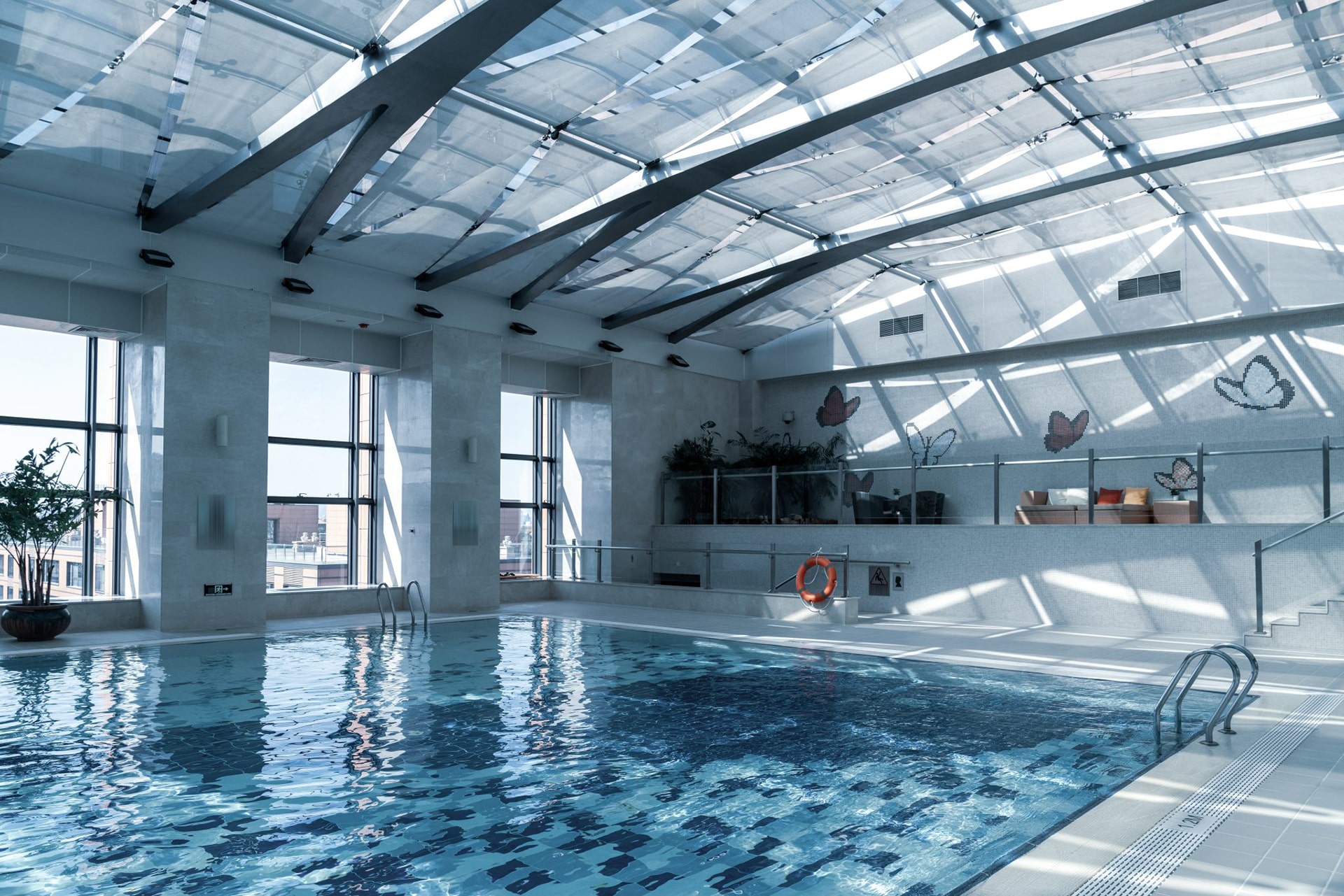 Modern indoor swimming pool with glass ceiling.