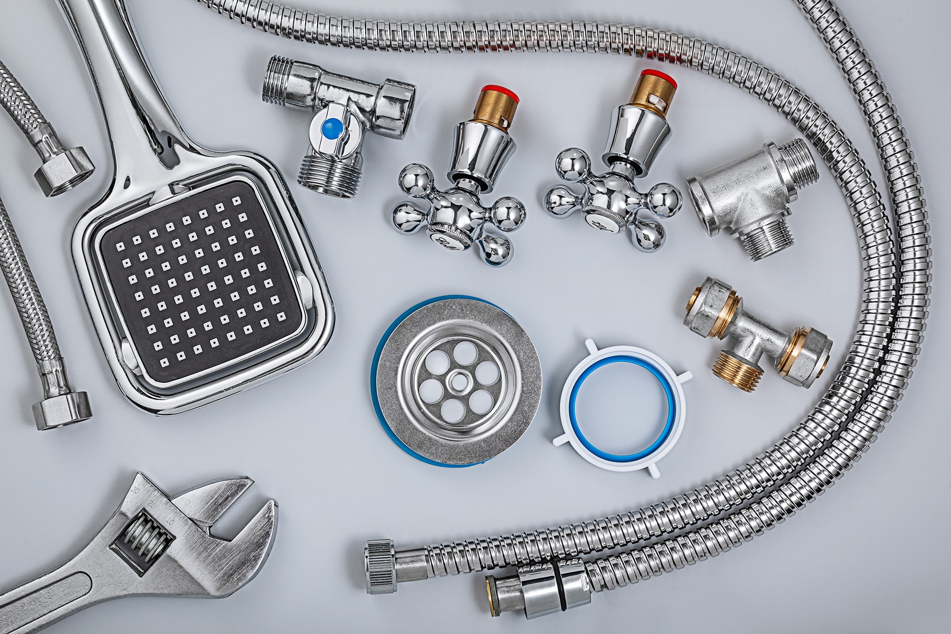 Plumbing tools and parts on gray background