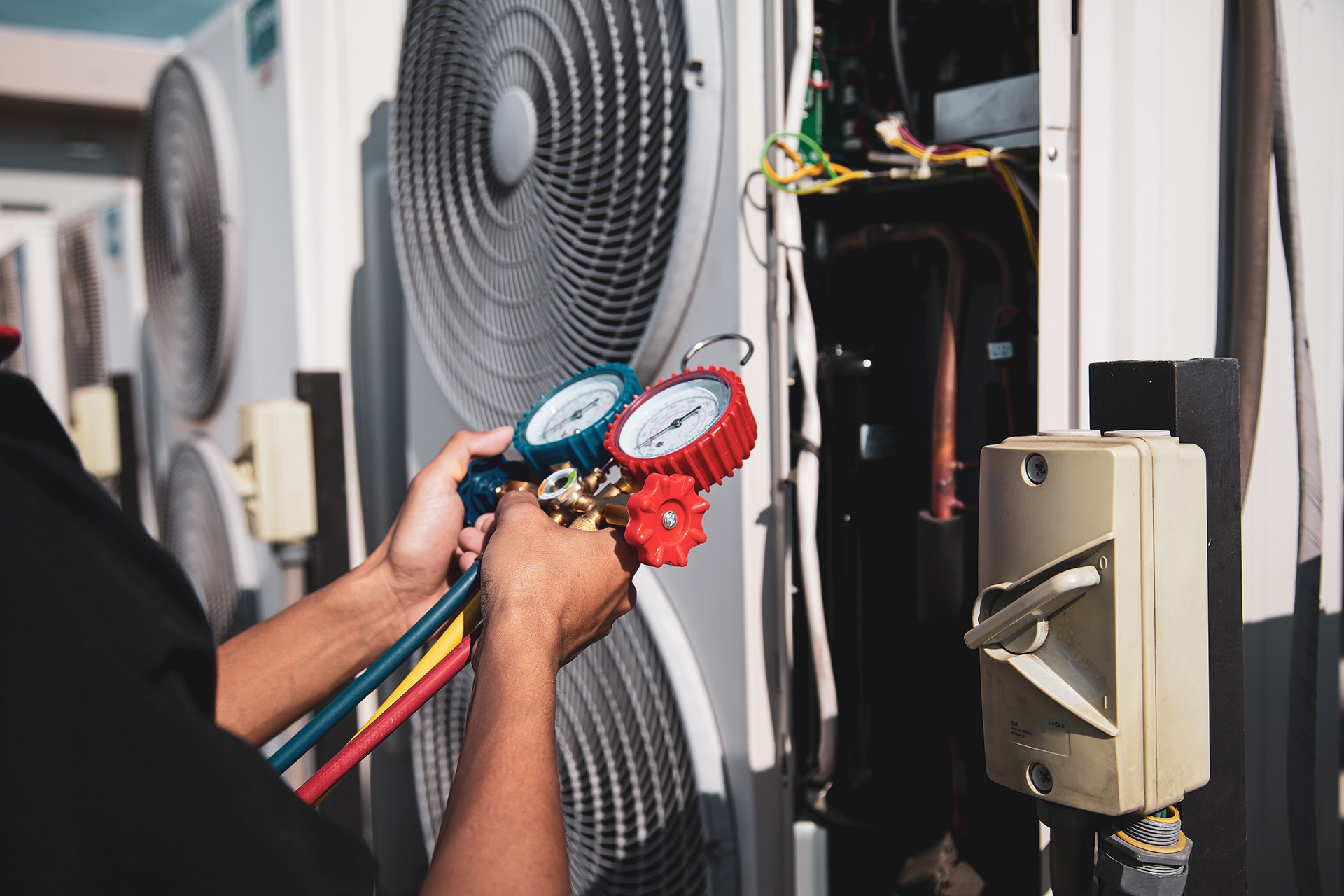 Technician measuring air conditioner pressure level