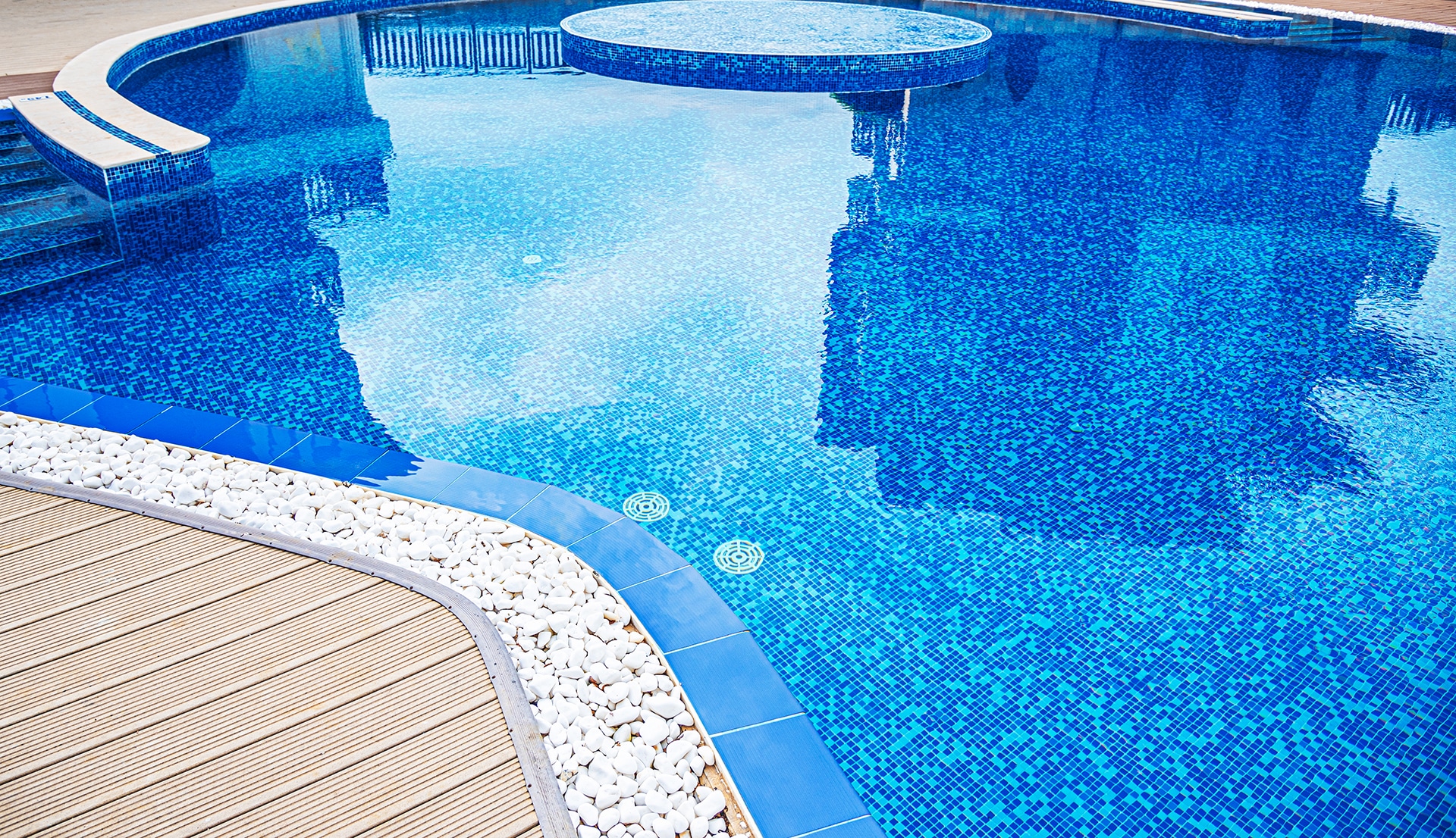 Modern tiled swimming pool with deck and stones