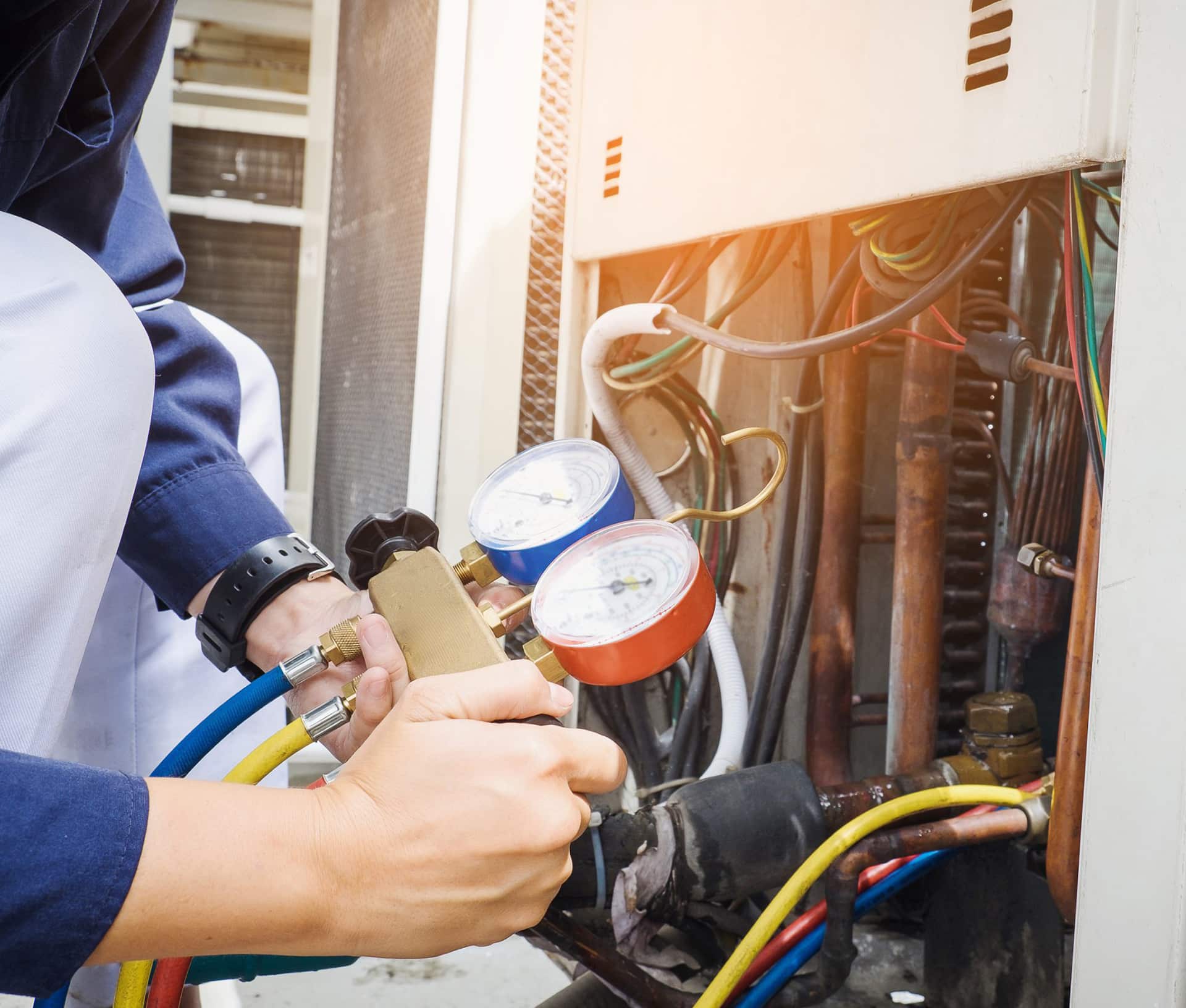 Technician adjusting air conditioning system gauges