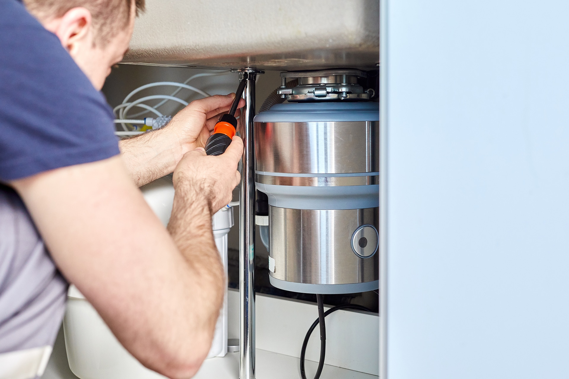 Person repairing kitchen sink plumbing