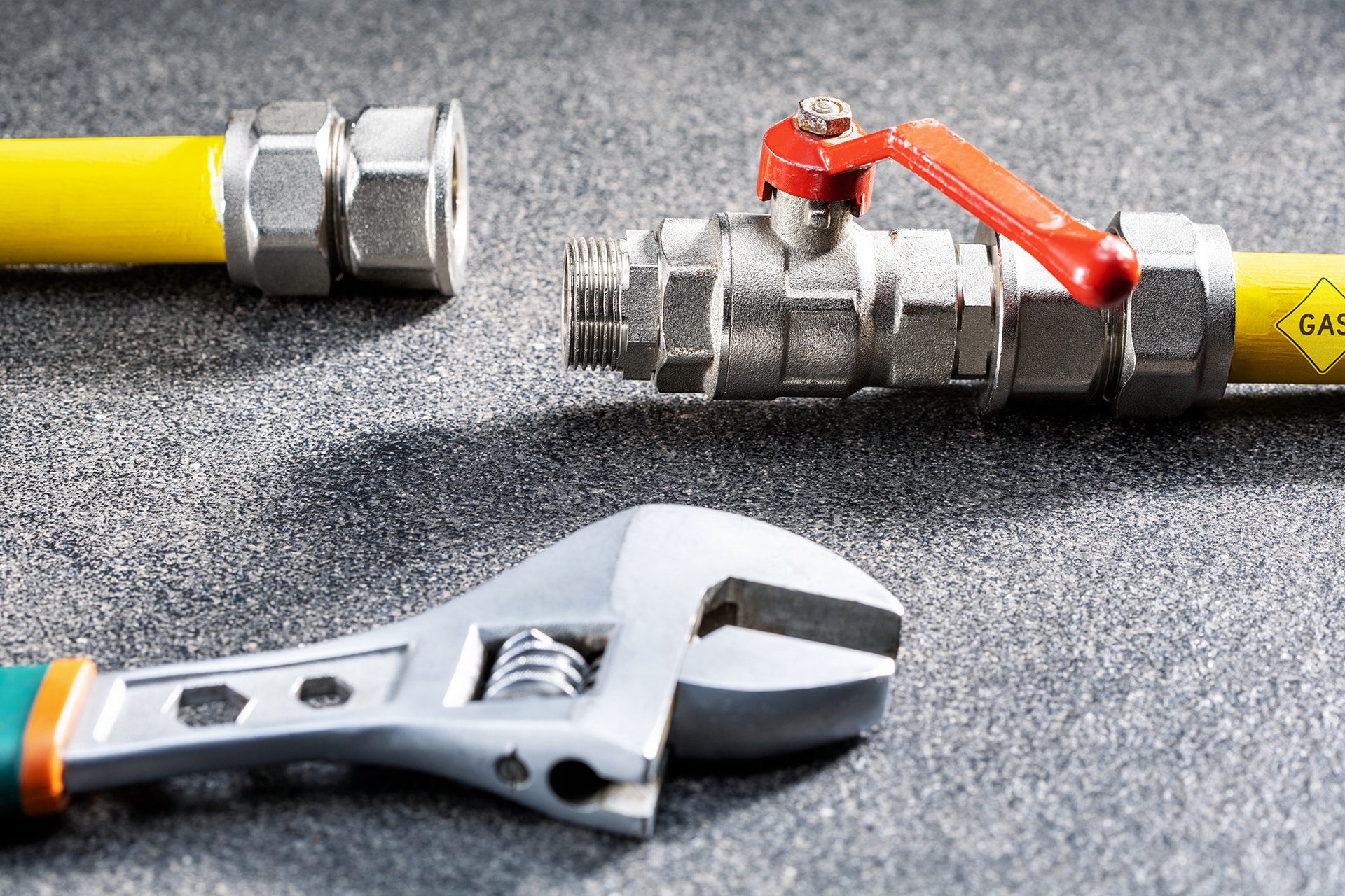 Gas pipe and wrench on workshop floor