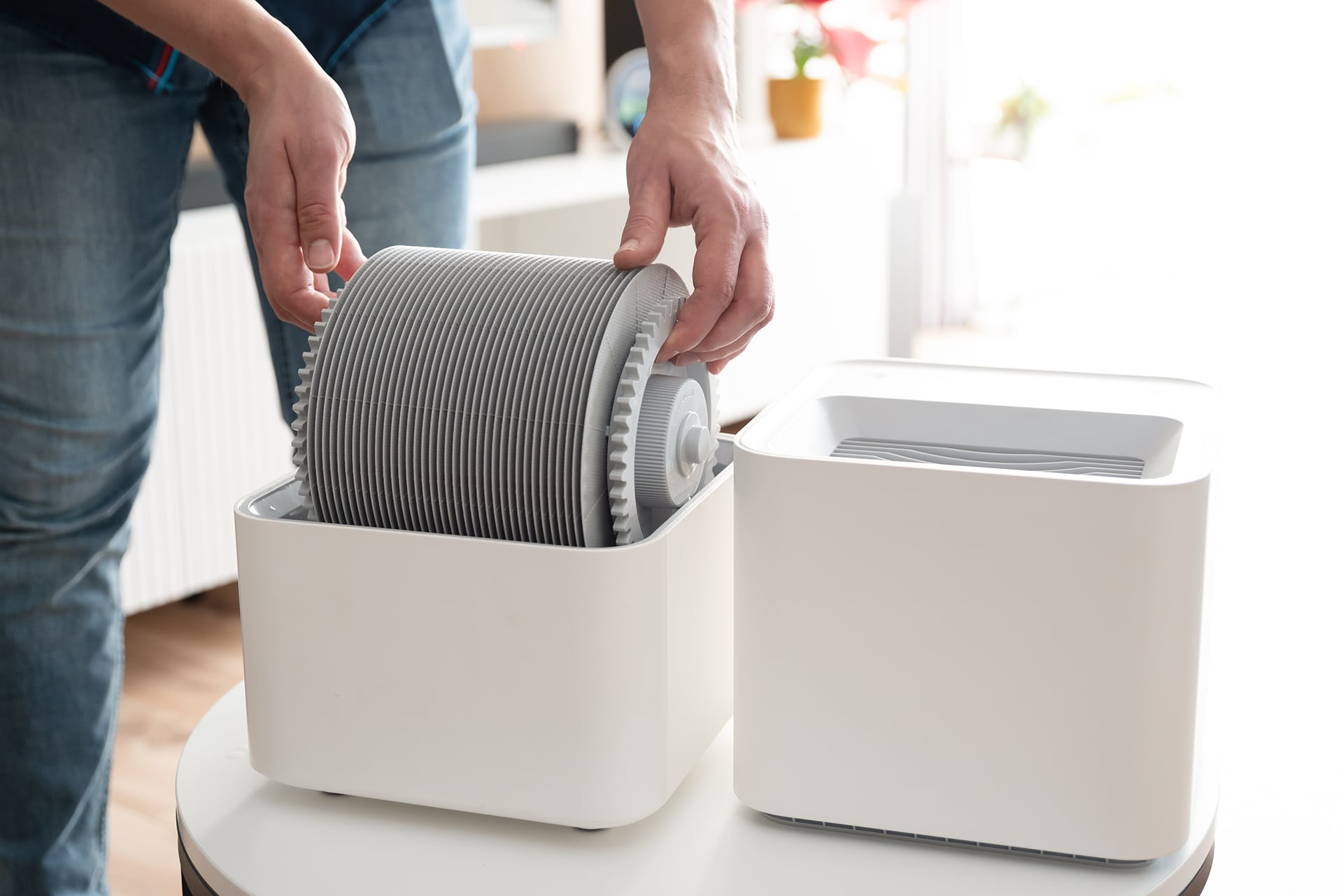 Person assembling air filter unit at home.