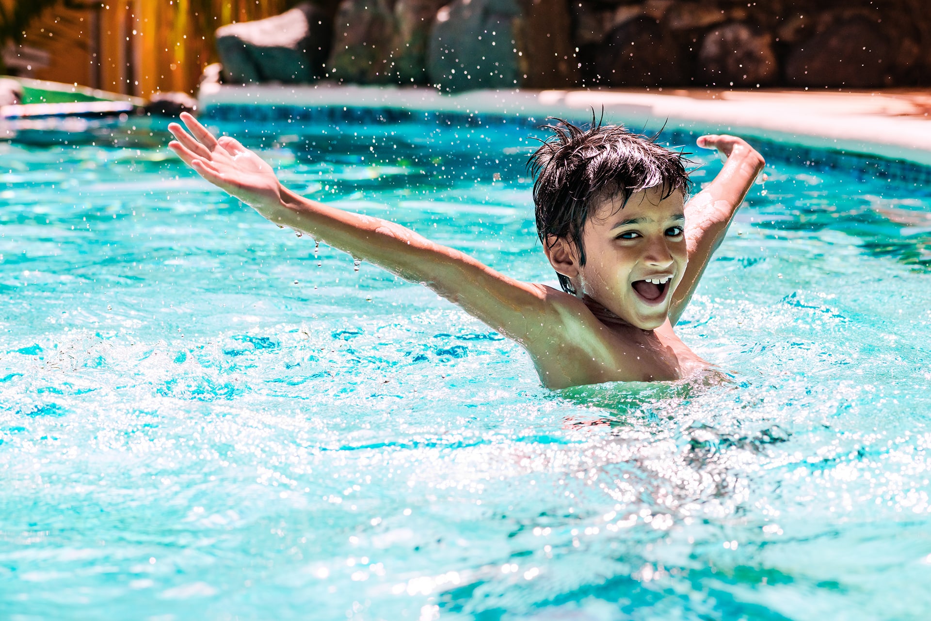 Child joyfully swimming in pool